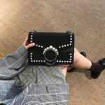 バッグをひざの上に置いている女性の下半身