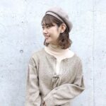 ベレー帽をかぶって横を向いている女性の上半身