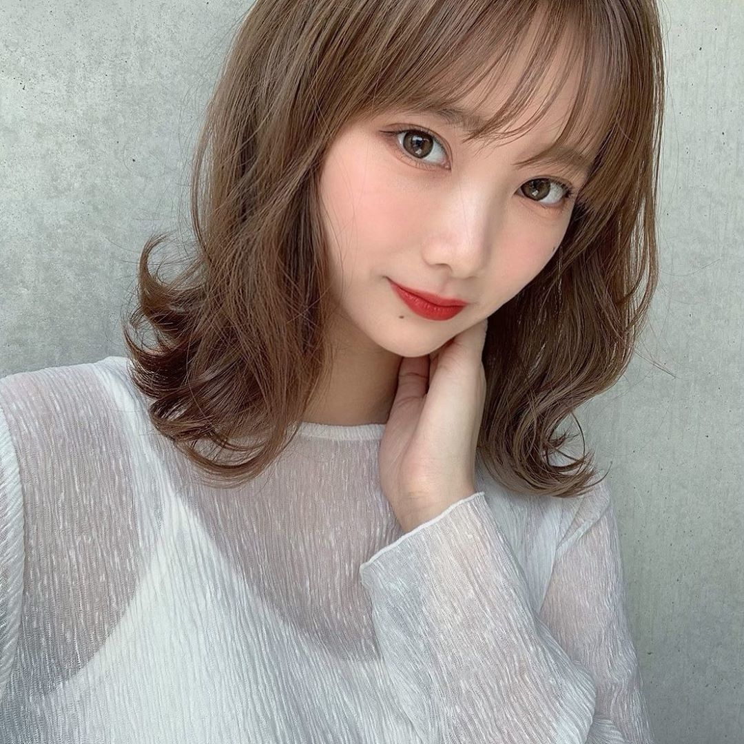 片手を首に置いている女性の顔