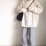 アーガイルニットとパンツコーデの女性