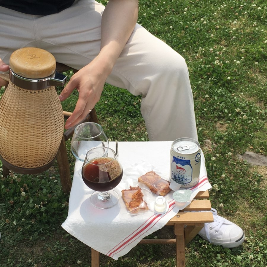 魔法瓶に入ったコーヒーと、小さなお菓子を太陽の下で