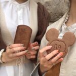ミッキーマウスのクッキーを持つ女性の手