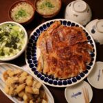 パリッとジューシーな羽根つき餃子が真ん中にある食卓