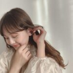 耳に手を当ててうつむく女性
