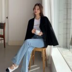 ジャケットを羽織って椅子に座っている女性