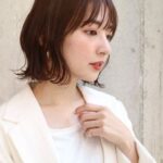 白いジャケットを羽織る女性の横顔