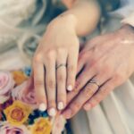 結婚した男女の指輪をつけた手先