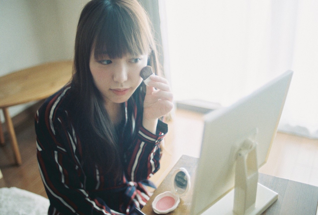 鏡の前でメイクをしている女性