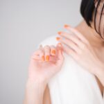 ネイルズインクのオレンジカラーの新色ネイルを塗った女性の横顔