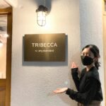 MisakiさんとTRIBECCACAFEのコラボ_TRIBECCACAFEの看板前で写真を撮るMisakiさん