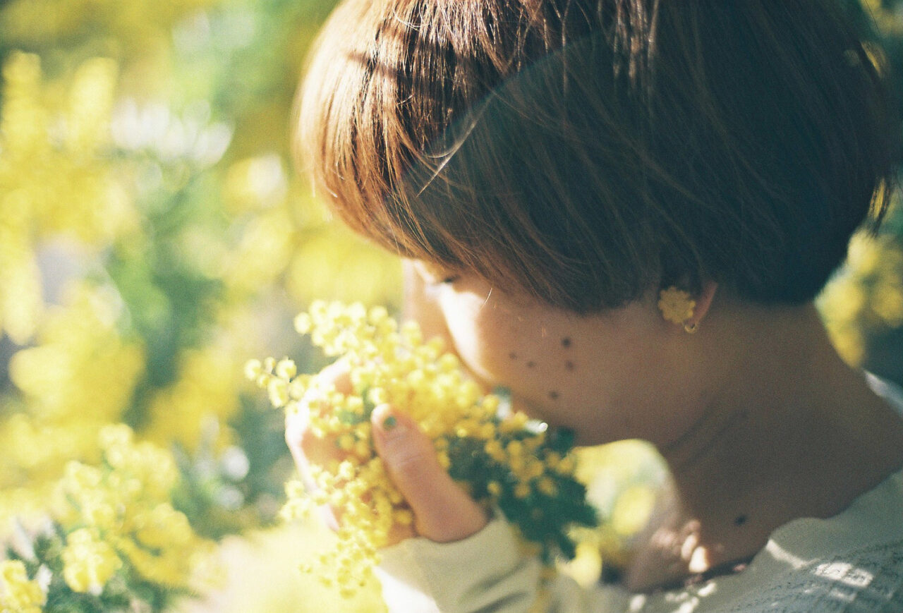 お花に顔を近づけている女性