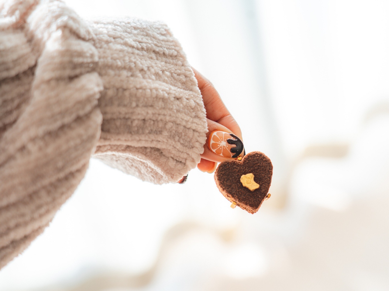 チョコの形のアクセサリーを持つ女性