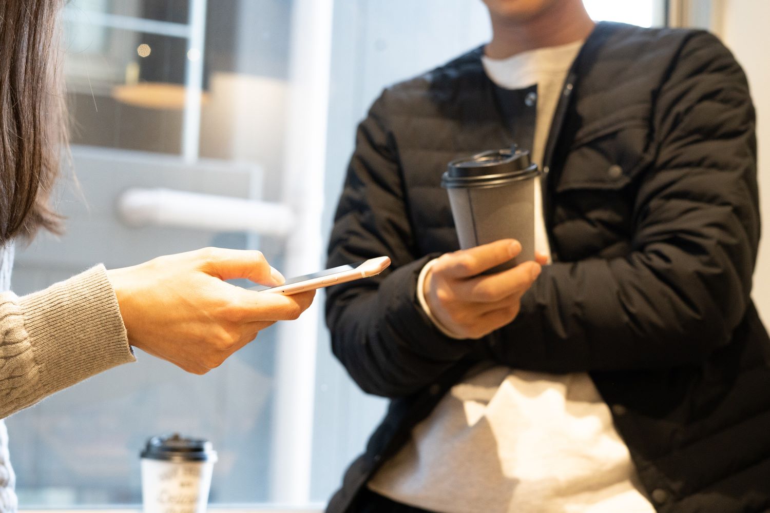 スマホやドリンクを持っている人々