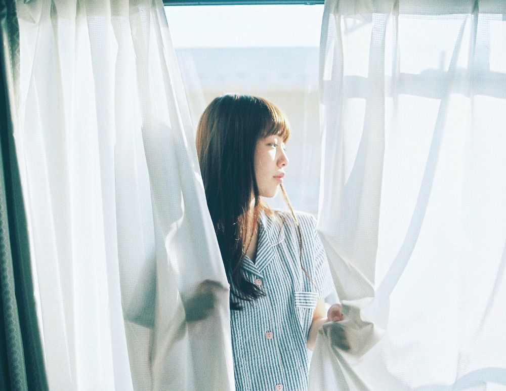 窓際に立つ女性